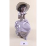 A Lladro figure of a seated girl holding flowers - boxed 'Sweet Fragrance'