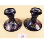 A pair of Moorcroft candlesticks 'Anemone' pattern on a blue ground - 9cm