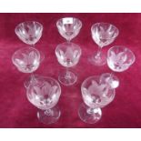A small group of long stemmed champagne and sherry glasses with frosted flower petals to bowl