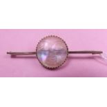 A moonstone brooch carved face of the moon on 9 carat gold pin (small crack)