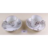 A pair of early 19th century coffee cups and saucers with sprigged floral decoration in manganese