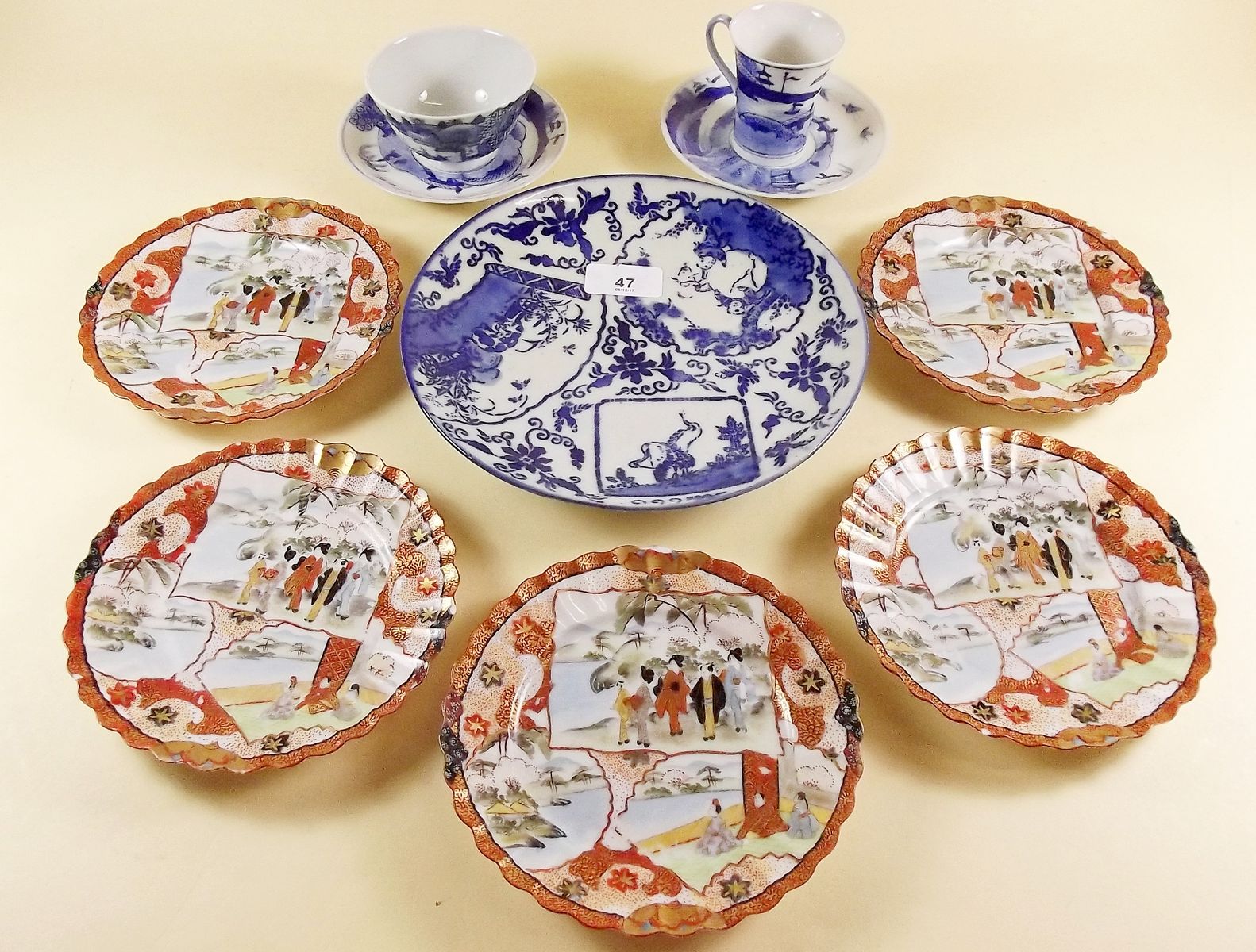 Two Japanese blue and white cups and saucers, five Kutani saucers and an Imari plate