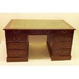An early 20th century mahogany twin pedestal desk with green leather inset top