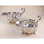A pair of silver frilled top and serpentine moulded sauce boats with hoof feet, London 1902 and 1909