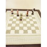 A Franklyn Mint chess set 'The Indian Sepoy Revolution 1857' in fitted chess board topped table