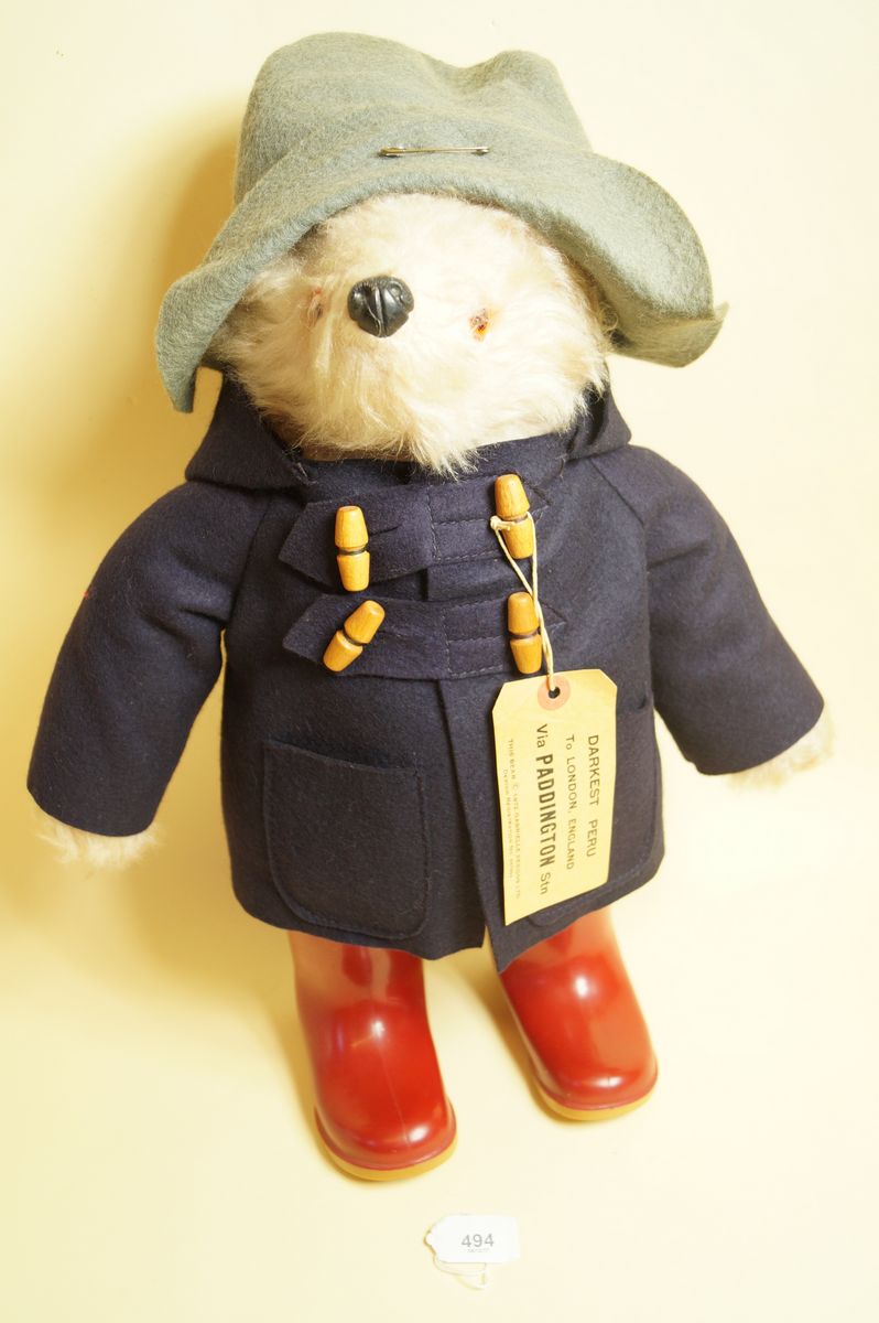 A Gabrielle Paddington Bear in navy blue coat and red Dunlop boots - good condition