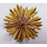 An 18 carat gold 'Sunburst' brooch set with rubies and sapphires