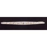 A white gold or platinum line brooch set twenty three graduated diamonds (total approx. 3 cts)