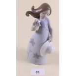 A Lladro figure of a girl holding a hat and flowers - boxed 'Little Violet'