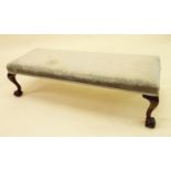 A Victorian long low stool on carved mahogany claw and ball feet, 93cm long