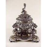 A 19th century heavy cast and silver plated inkwell with all over scrollwork decoration and putti to