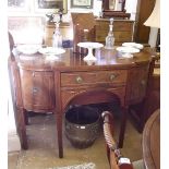 A George III mahogany breakfront sideboard with bow fronted drawer and cupboard flanking frieze