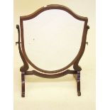 A shield form mahogany swing toiletry mirror