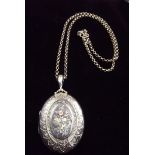 A Victorian silver oval locket inlaid rose spray in coloured gold, on silver chain