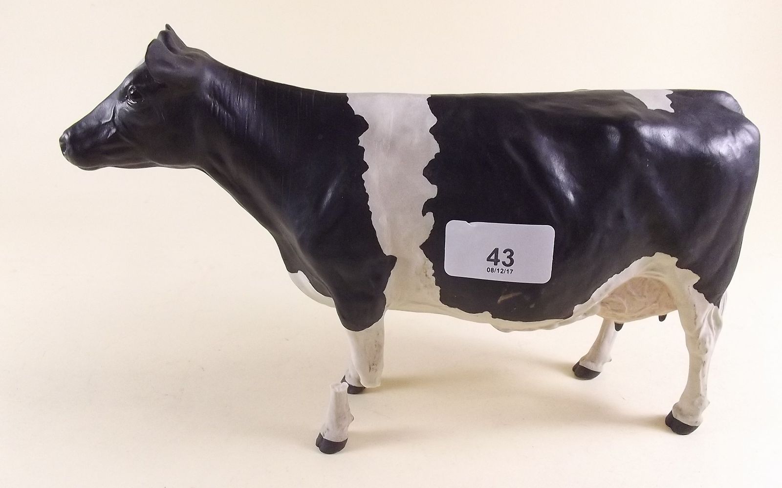 A porcelain cow by Harper Shebeg Isle of Man - 28cm long - two legs a/f