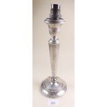 A silver candlestick converted to a table lamp