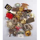 A box of various brooches