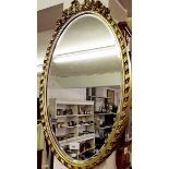 A gilt framed oval mirror with ribbon surmount 63 x 33cm