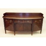 An early 19th century Irish mahogany bow fronted sideboard with ebony inlay, the six turned supports