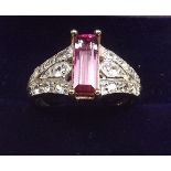 A 9K gold pink tourmaline ring on diamond set shoulders, size O
