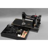 A Singer Featherweight 221K Sewing Machine, complete with various accessories in maker's case