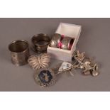 A collection of silver and white metal jewellery and napkin rings, including a charm bracelet, a