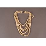 A modern five strand pearl necklace, the white graduated pearls on knotted string united by a