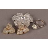 A modern white metal and large zircon solitaire ring, together with a paste set flower brooch and