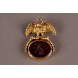 A Victorian gold and hardstone spinning seal, having a spread eagle to upper supporting a