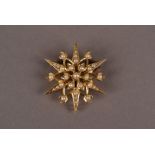 A late Victorian 15ct gold and seed pearl brooch cum pendant, the star burst design set with small