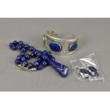 A lapis lazuli white metal cuff bangle, a bead necklace with polished drop and a pair of earrings (