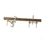 Very unusual metal model of a chopped log on heavy wire supports with woodcutters tools attached,