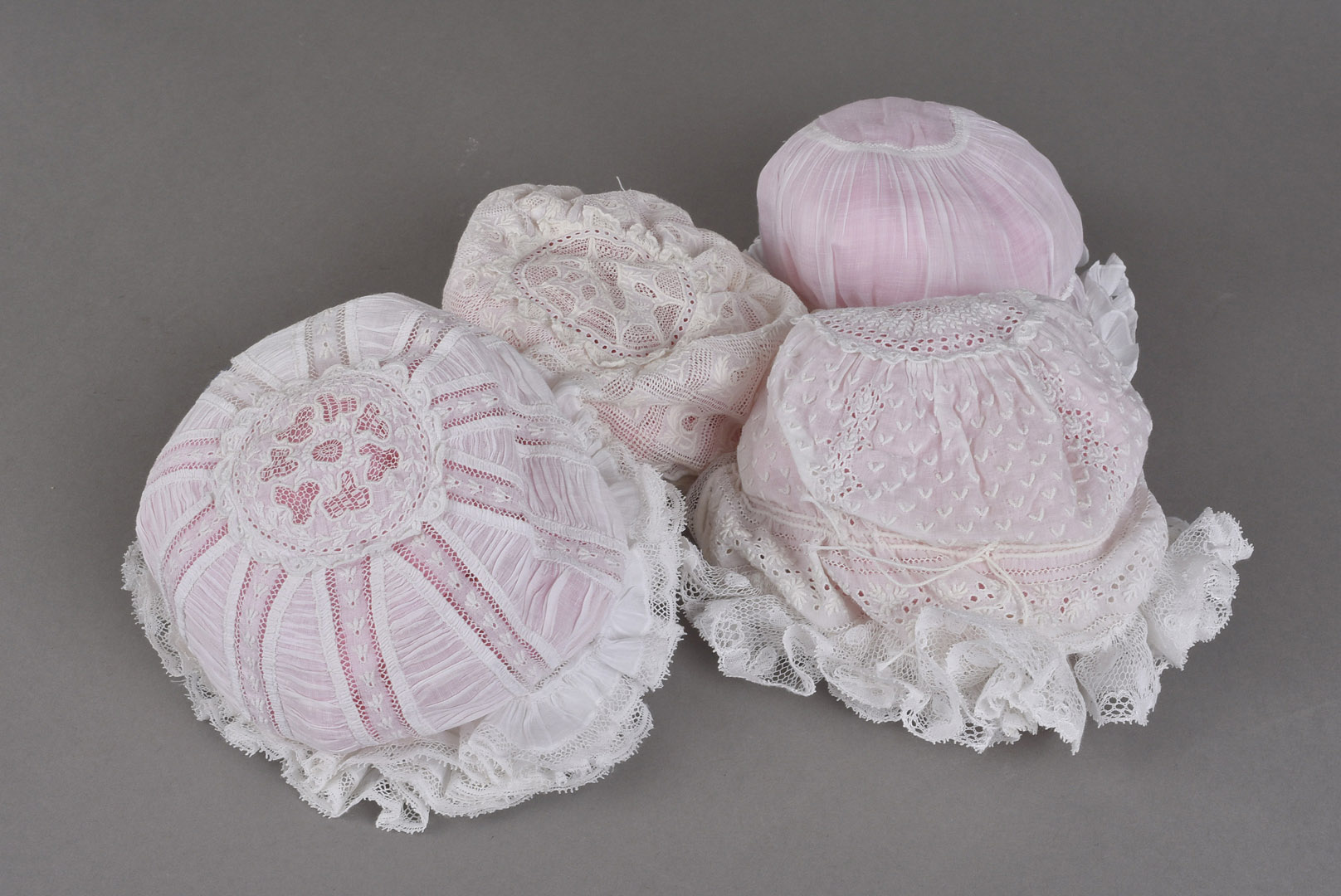 A collection of 19th century and later crochet bonnets, plus christening gowns, dresses, and