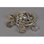 A collection of silver jewellery, including bangles, an amber ring, silver cross, heart locket,