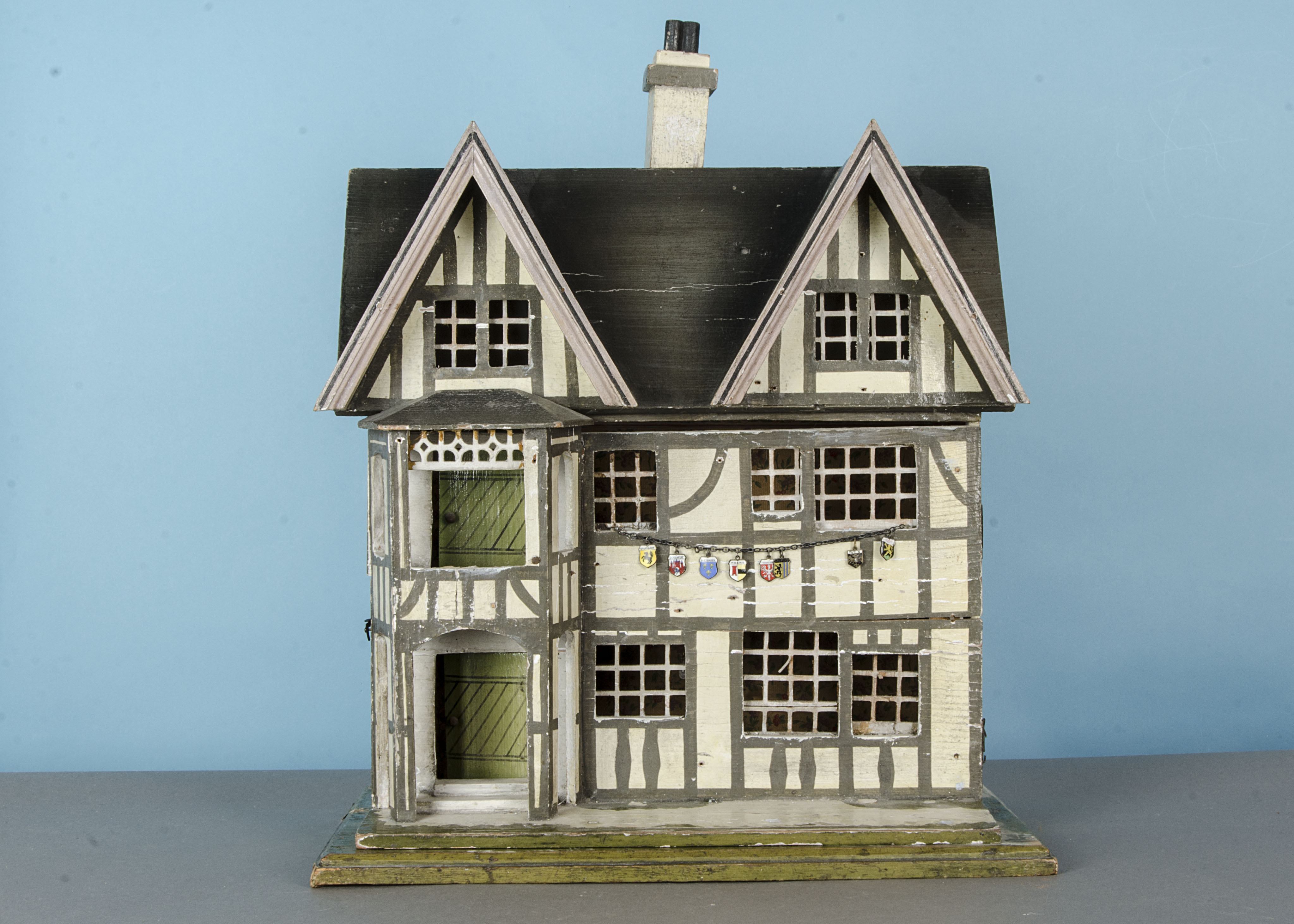 A German timber-framed dolls’ house, early 20th century, cream and grey painted, front door with