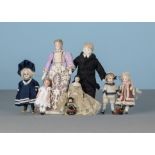 Dolls’ house dolls: a German all-bisque girl in sailor’s suit; two similar smaller girls; an all-