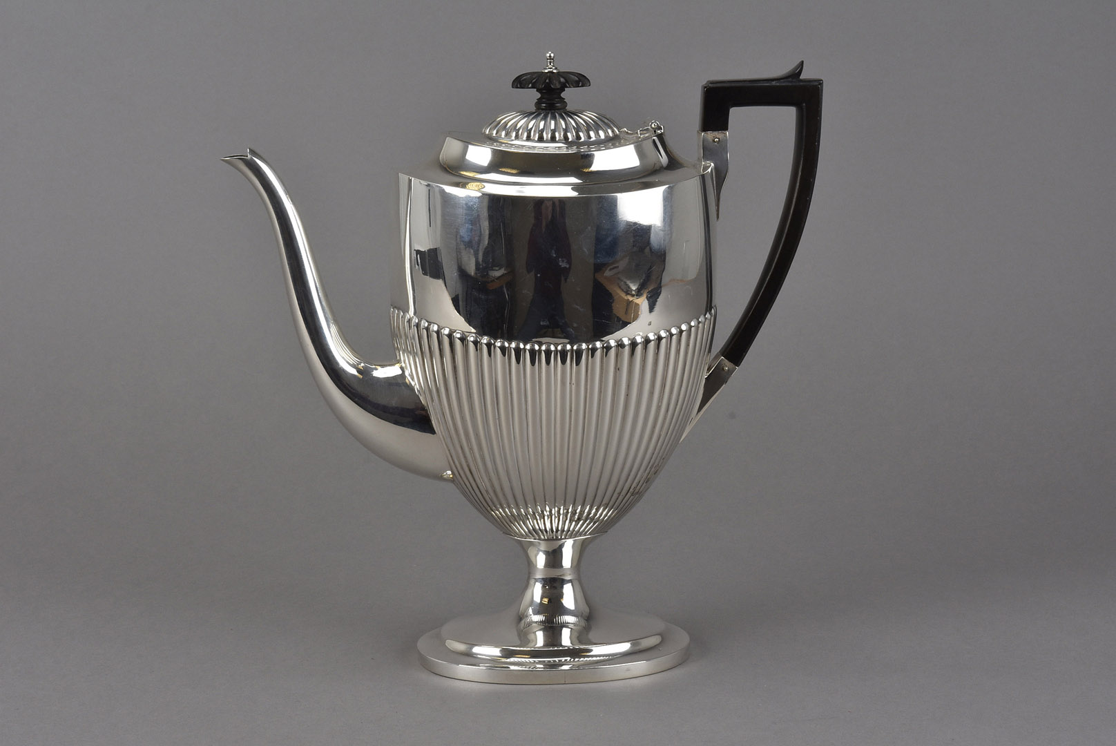 A late Victorian silver hot water pot by SWS, oval spreading foot with fluted lower, London 1892,