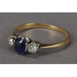 A pretty Edwardian period three stone ring, centred with a blue sapphire and flanked by a pair of