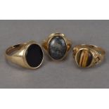 A group of three gentlemen's hardstone signet rings, one a 9ct gold example with moss agate, another