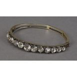 A pretty Victorian silver gilt and paste set bangle, luckily set with 13 clear glass stones, in