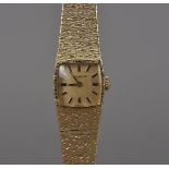 A 1960s 9ct gold Longines lady's wristwatch, cushion shaped dial, with integrated textured finish