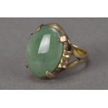 A vintage Chinese hardstone signet ring, the jade style oval panel in gilt metal mount