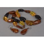 A modern Baltic amber bead necklace and earrings, having yellow, orange and dark amber pieces, the