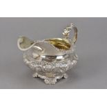A George IV silver cream or milk jug by RP GB, squat form with embossed floral design, London