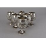 A set of six vintage Indian white metal wine goblets, having raised scene of a man and elephant in a