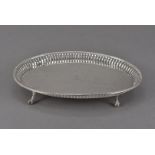 A George III silver teapot stand by WT, oval with pierced sides, bearing engraved family crest,
