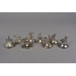 A set of eight vintage Thai silver menu holders, circular bases with figures or boats, marked Siam