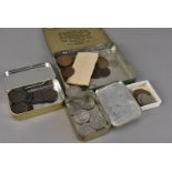 A diverse collection of British and World coins, presented in tins and small cardboard boxes,