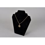 A Victorian 15ct gold and seed pearl circular pierced pendant, on a 15ct gold rope twist necklace,