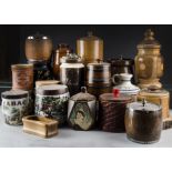 A collection of eighteen wooden tobacco jars, mostly turned fruit woods and oak, some with porcelain